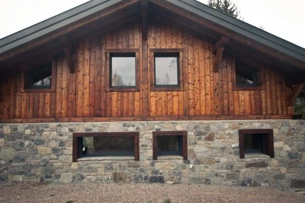 chalet de montagne avec bardage bois brûlé brossé et soubassement en pierre