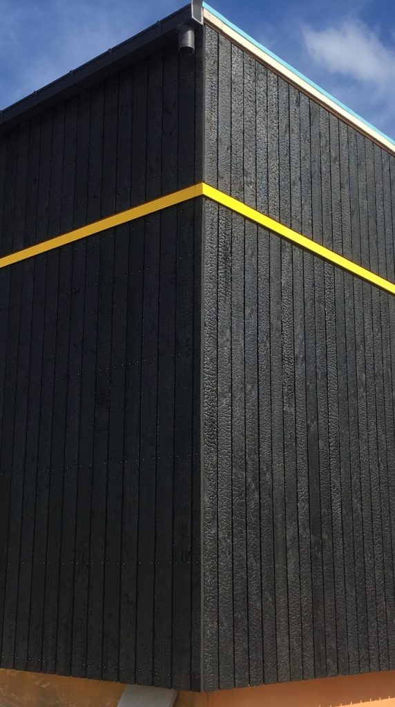 Angle de batiment en bois brûlé avec une ligne jaune