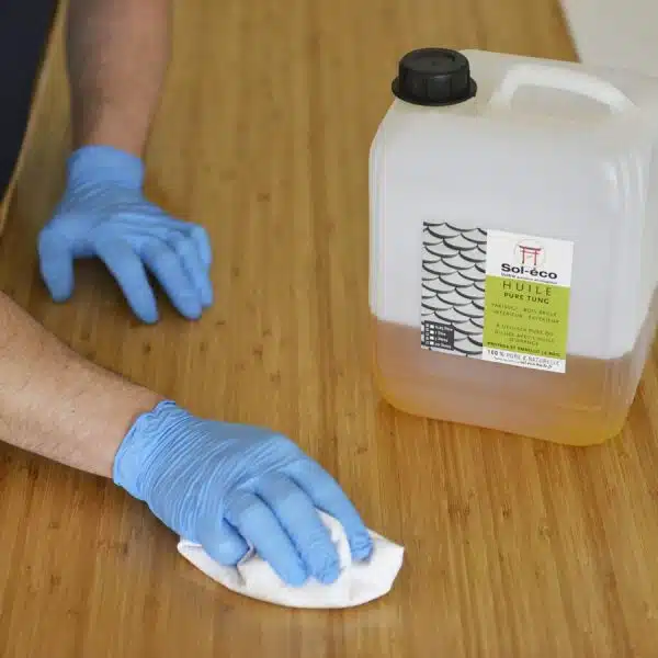 essuyage des surplus d'huile de tung à l'aide d'un chiffon