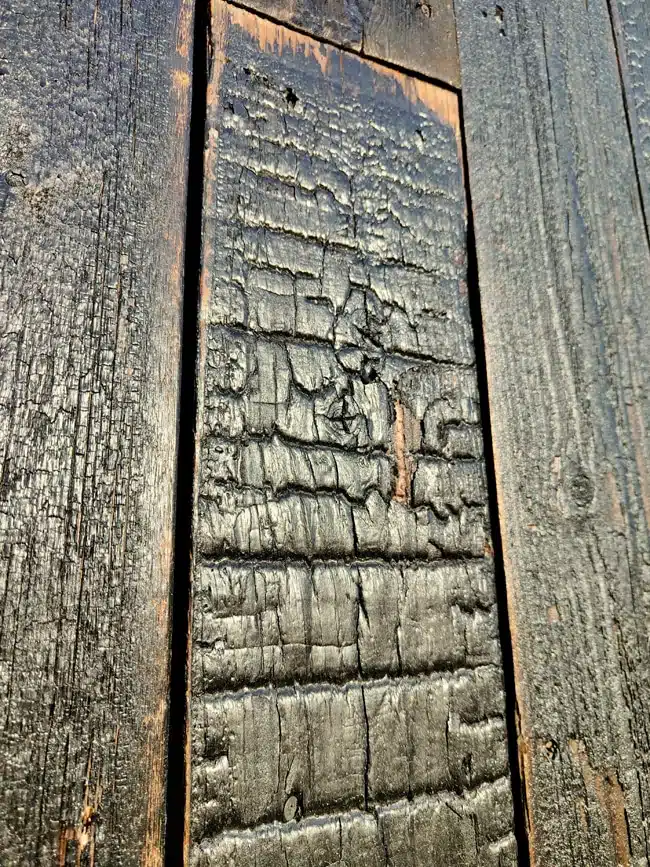 écaille de bois brûlé qui se détache